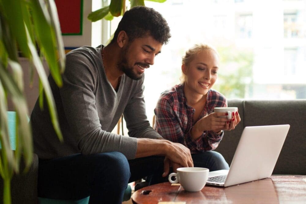 Young Couple Using Laptop In A Cafe